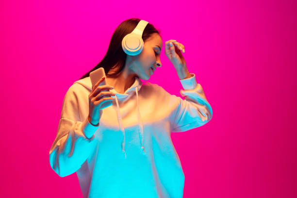 istock Caucasian beautiful woman's portrait isolated on pink studio background in multicolored neon light 1297174881