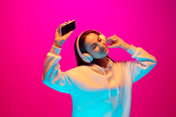 istock Caucasian beautiful woman's portrait isolated on pink studio background in multicolored neon light 1297174885