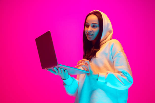 istock Caucasian beautiful woman's portrait isolated on pink studio background in multicolored neon light 1297174890