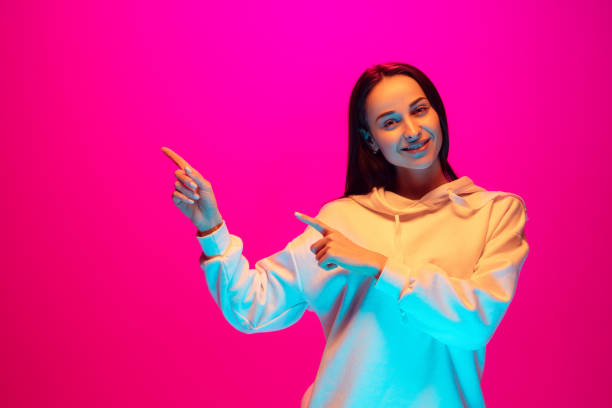 istock Caucasian beautiful woman's portrait isolated on pink studio background in multicolored neon light 1297174898
