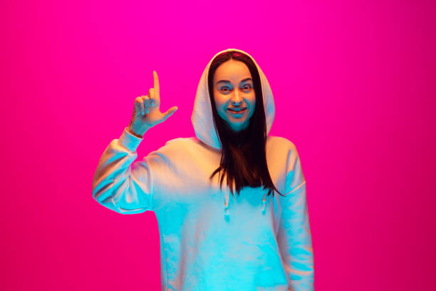 istock Caucasian beautiful woman's portrait isolated on pink studio background in multicolored neon light 1297174899