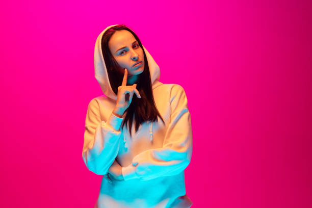 istock Caucasian beautiful woman's portrait isolated on pink studio background in multicolored neon light 1297174905