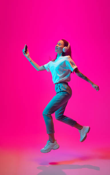 istock Caucasian beautiful woman's portrait isolated on pink studio background in multicolored neon light 1297174906