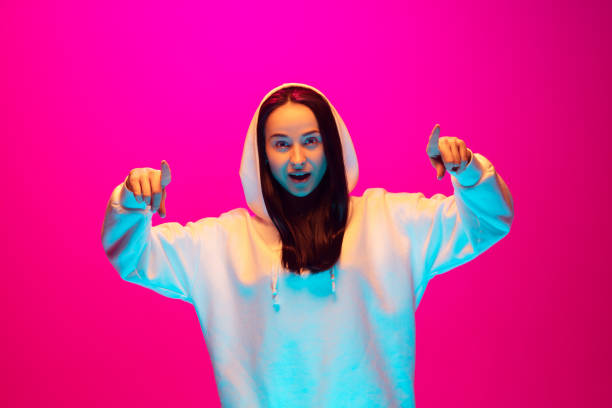 istock Caucasian beautiful woman's portrait isolated on pink studio background in multicolored neon light 1297174907