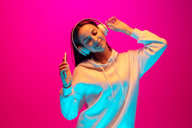 istock Caucasian beautiful woman's portrait isolated on pink studio background in multicolored neon light 1297174910