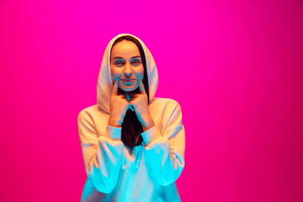 istock Caucasian beautiful woman's portrait isolated on pink studio background in multicolored neon light 1297174911