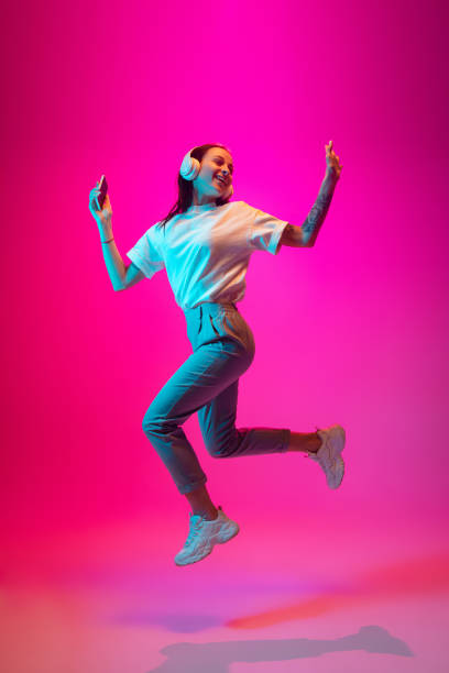 istock Caucasian beautiful woman's portrait isolated on pink studio background in multicolored neon light 1297174913
