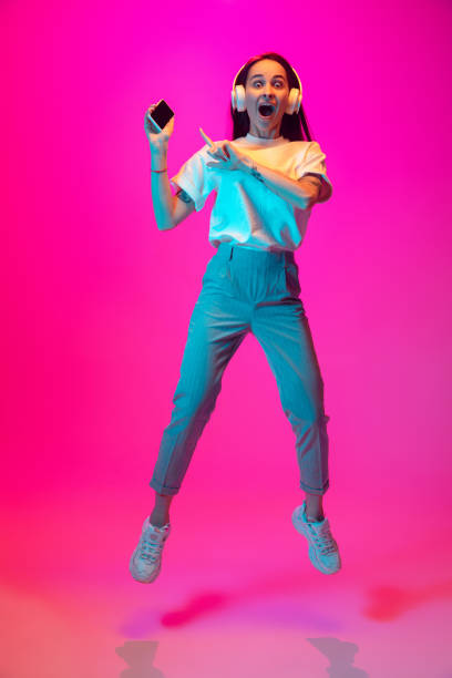 istock Caucasian beautiful woman's portrait isolated on pink studio background in multicolored neon light 1297174919