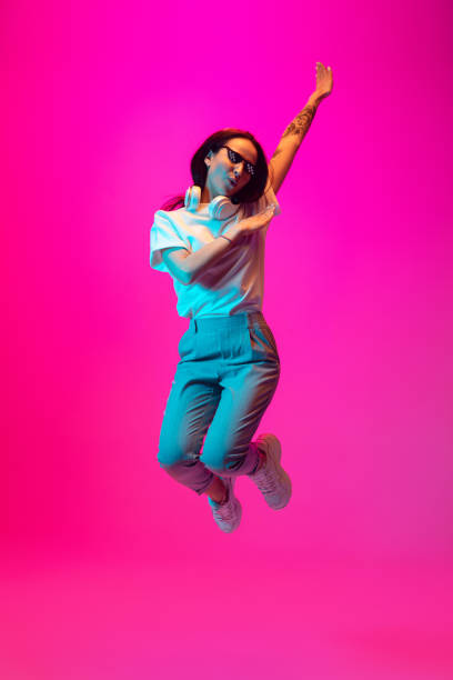 istock Caucasian beautiful woman's portrait isolated on pink studio background in multicolored neon light 1297174920