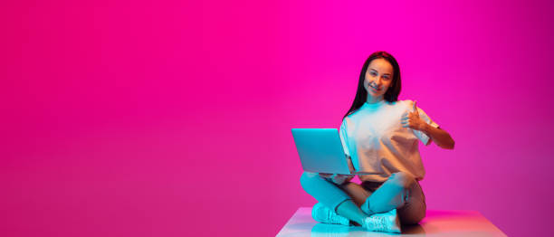 istock Caucasian beautiful woman's portrait isolated on pink studio background in multicolored neon light 1297174933