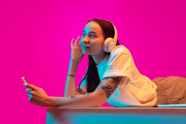 istock Caucasian beautiful woman's portrait isolated on pink studio background in multicolored neon light 1297175159
