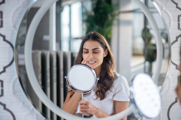 istock Woman looking at the small mirror in her bathroom 1297175448