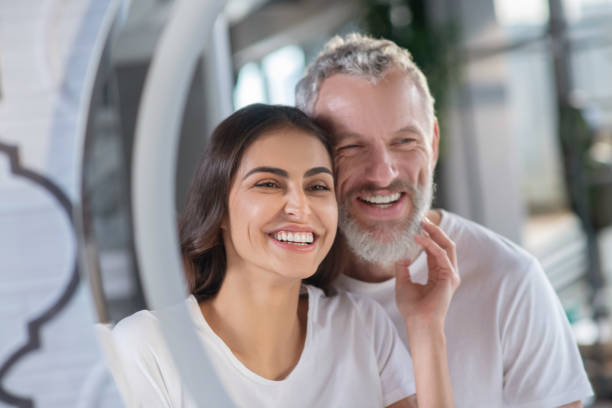 Smiling man and woman looking at the mirror Happy morning. Smiling man and woman looking at the mirror age contrast stock pictures, royalty-free photos & images