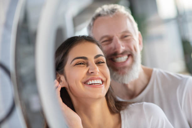 istock Smiling woman and man looking at the mirror 1297175475