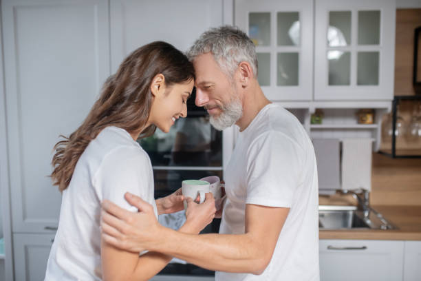 Man and woman hugging each other while having coffee In love. Man and woman hugging each other while having coffee age contrast stock pictures, royalty-free photos & images