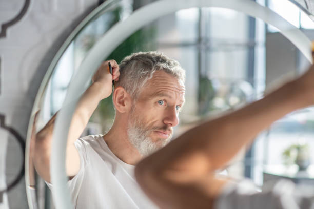 homem penteando seu cabelo de manhã - cabelo grisalho - fotografias e filmes do acervo