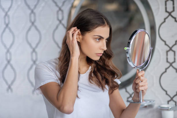 istock Woman looking at the small portable mirror 1297175687