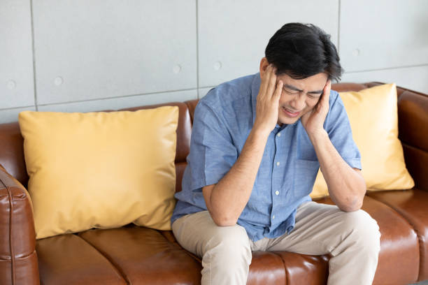 istock senior asian man suffering from headache at home 1297177258