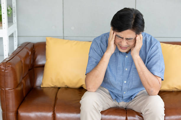 istock senior asian man suffering from headache at home 1297177280