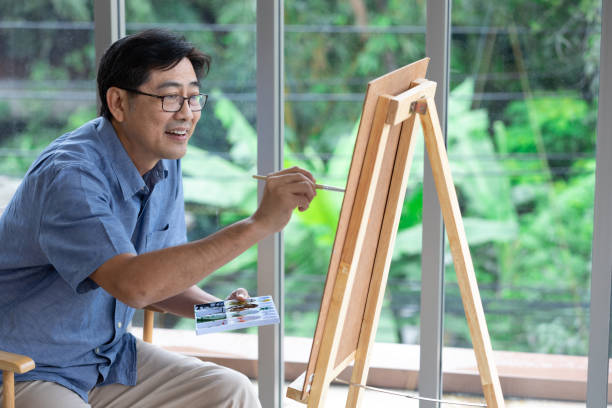 istock senior asian man painting at home 1297177444