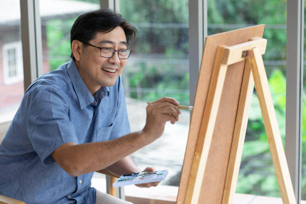 istock senior asian man painting at home 1297177464