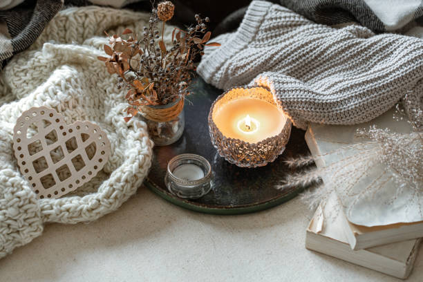 istock Cozy home composition with a burning candle and knitted elements. 1297180261