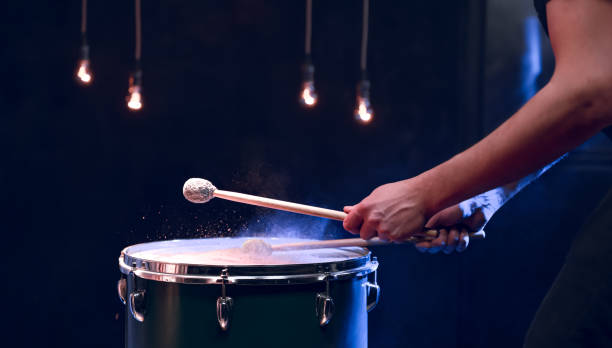 istock The drummer plays with mallets on floor tom in dark room. 1297180311