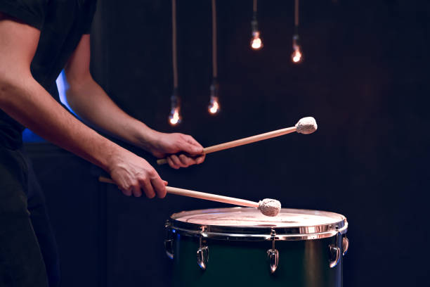 istock The drummer plays with mallets on floor tom in dark room. 1297180320