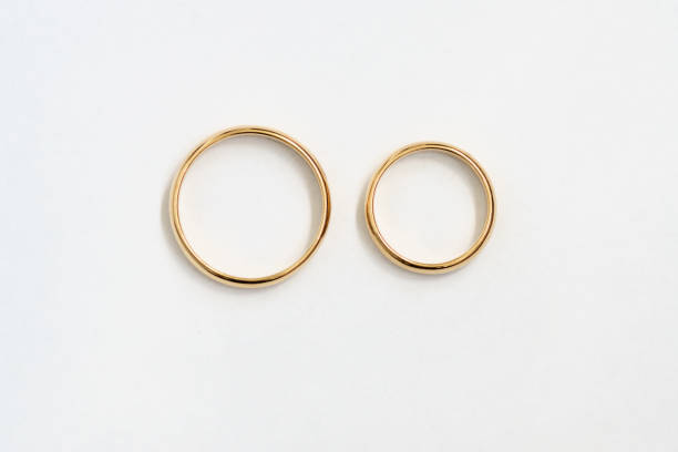 istock Two gold wedding bands on a white background. 1297181211