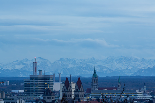 A look with a moon lens to the east side of Munich in Germany with the alps far in the background during the blue hour of a winter day
