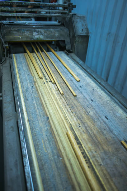 istock hardwood sticks entering lacquering machine 1297182586