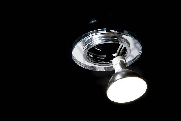 istock Mounting led ceiling lamp or recessed halogen lights on black suspended ceiling in room, close up. 1297184975