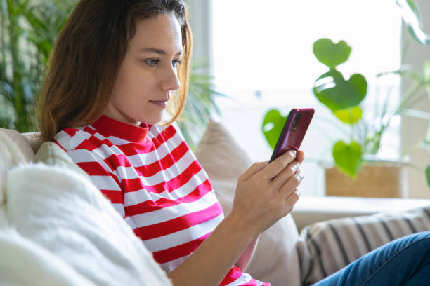 istock Young woman using phone at home 1297185931