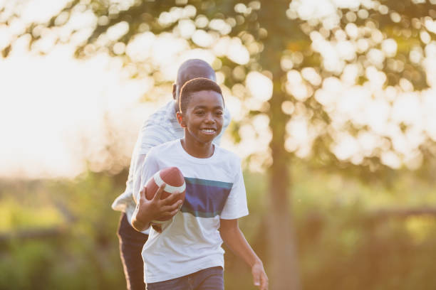 istock Father and son playing backyard football 1297186098