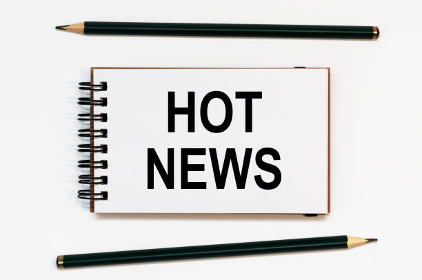istock WHITE SPIRAL NOTEBOOK, TWO PENCILS WITH HOT NEWS 1297188104