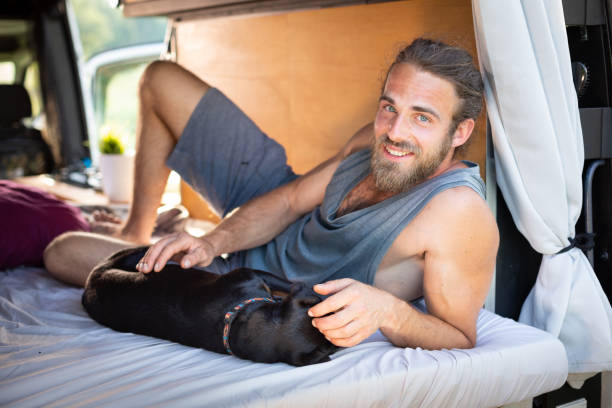 istock Man and his dog lying inside a camper van 1297189759