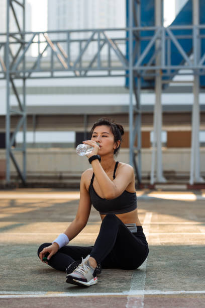 istock Taking a Break: Thirsty Runner Drinking Water after an Exhausting Running Session 1297189859