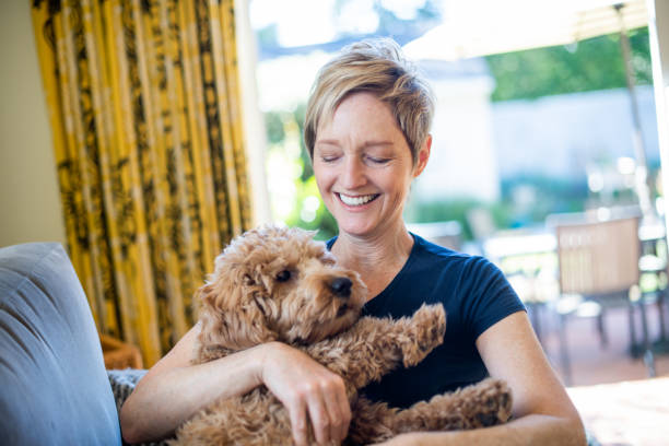 istock Smiling older woman relaxing at Home with her Dog 1297190265