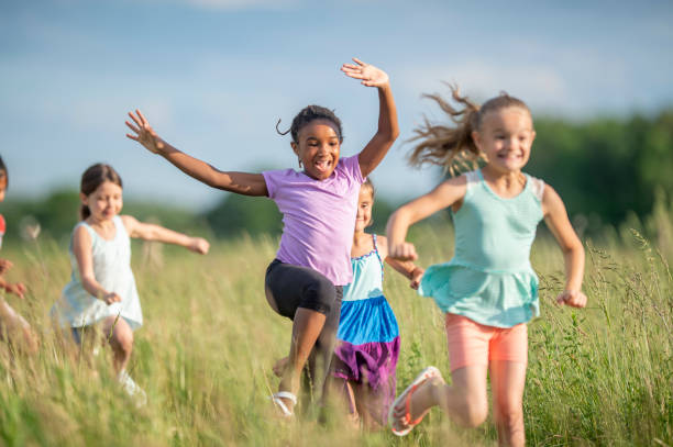 istock Kids running and laughing in a meadow 1297190684