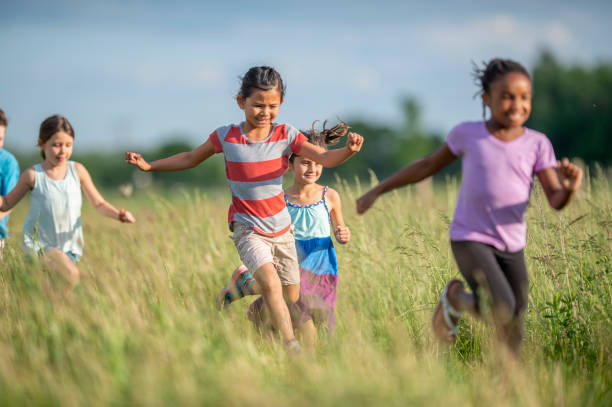 istock Kids running and laughing in a meadow 1297190687