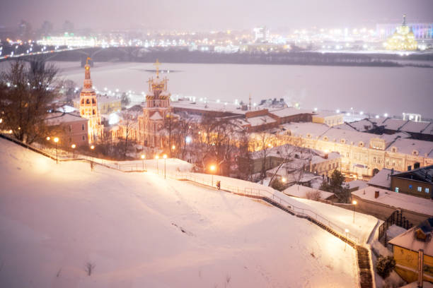 Aerial view of illuminated historical buildings and river at winter night. Nizhny Novgorod, Russia.