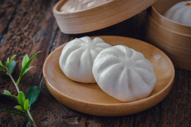 istock Steamed pork buns on wooden plate, Chinese dim sum 1297193152