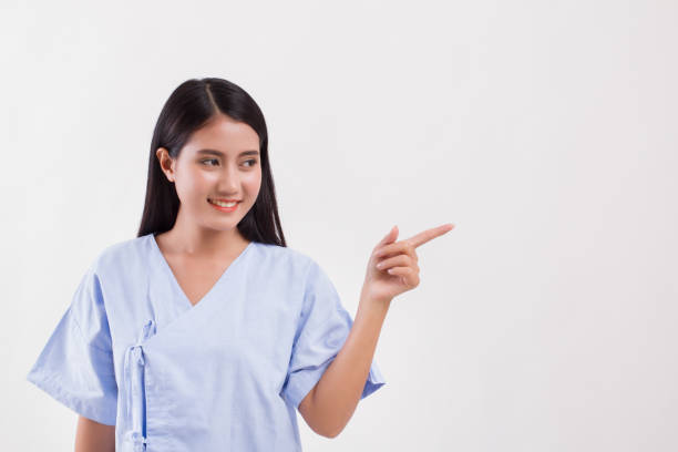 istock woman patient pointing finger up to blank space 1297193577