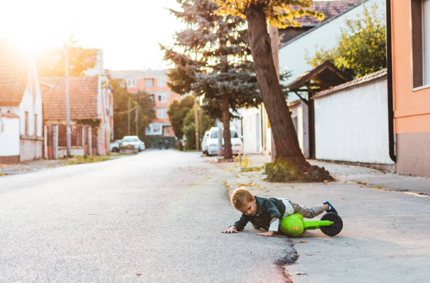 istock Boy fall down while riding motorcycle around the neighborhood 1297193753