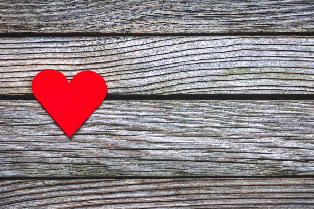 istock Red paper heart on wooden background 1297196005