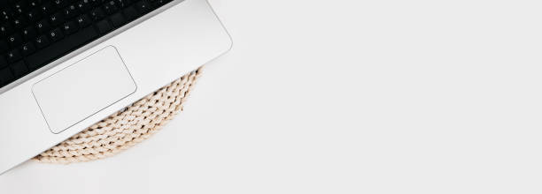 istock long format, banner black keyboard of stylish silver thin laptop on woven eco-friendly stand made of recycled materials on white table, selective focus 1297196597