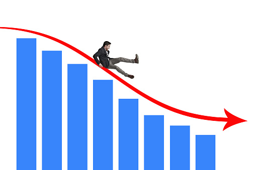 Shot of a businessman falling off a graph against a white background