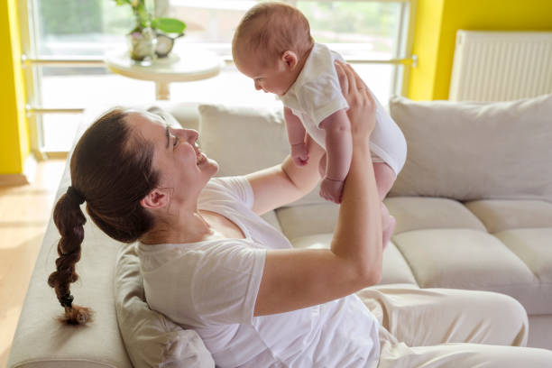 istock mom plays with her newborn baby 1297197014