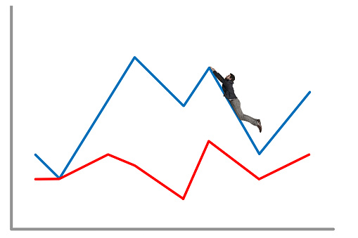 Shot of a businessman falling off a graph against a white background