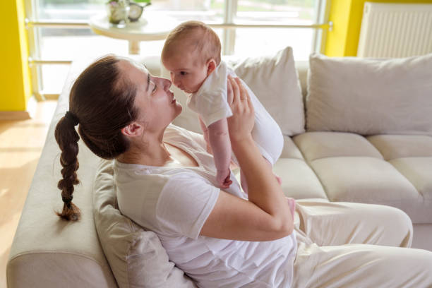 istock mom plays with her newborn baby 1297197053